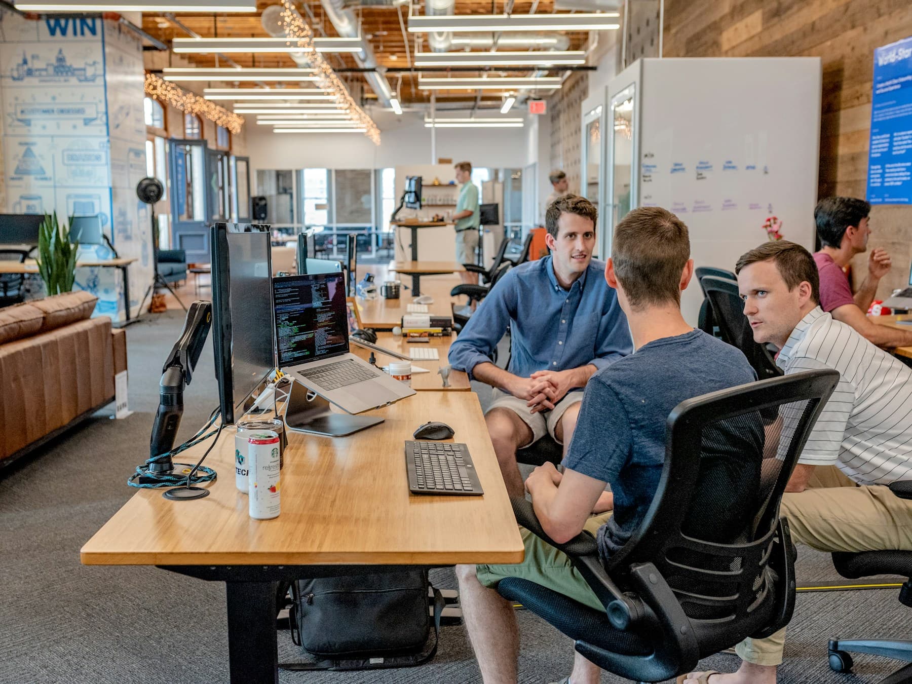 Software colleagues discussing work in an open office