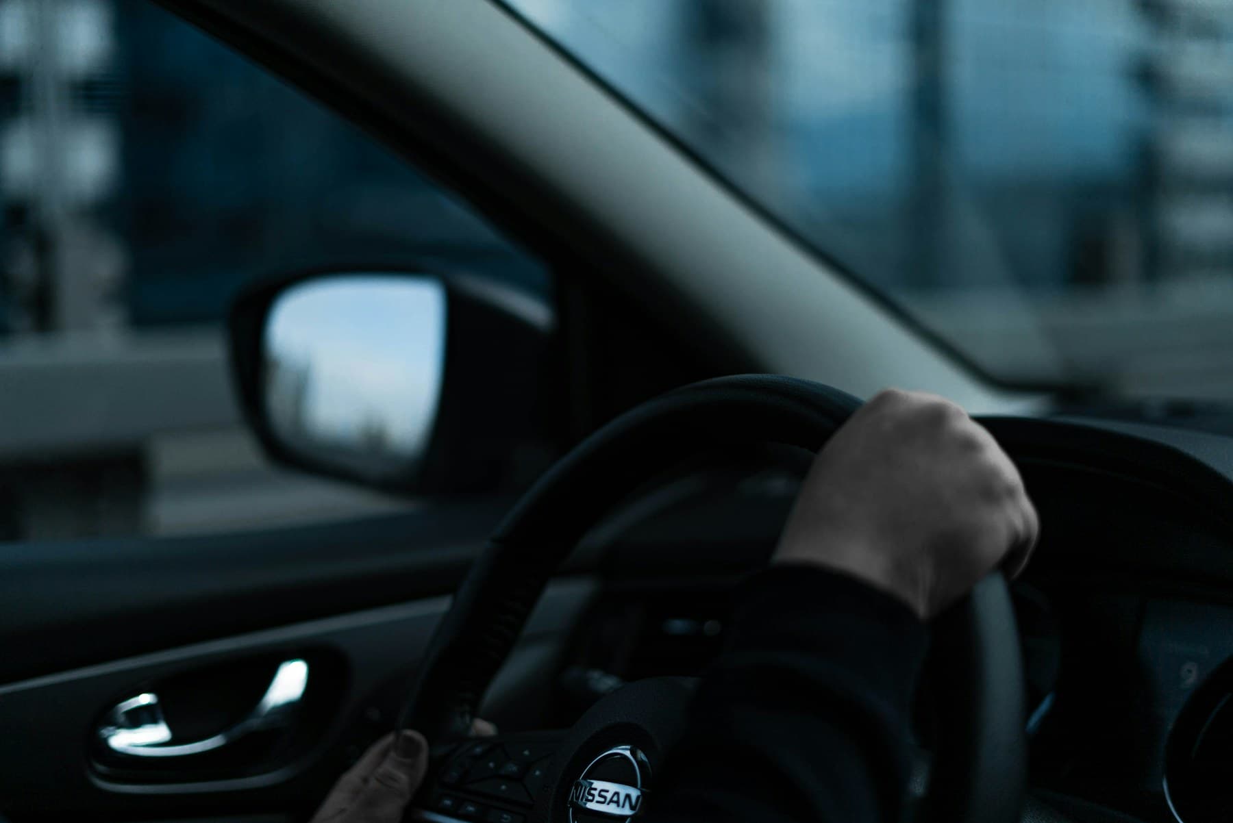A driver holding the wheel during a city journey