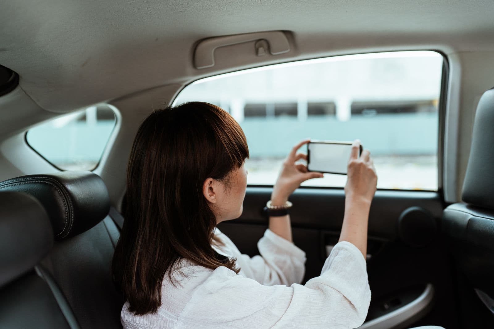 A rider checking the trip on their phone from the back seat